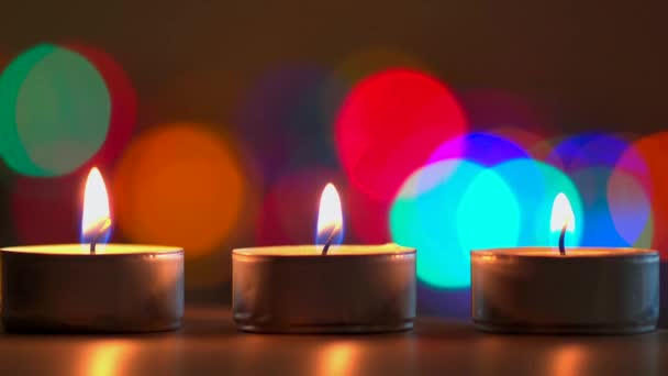 close-up view of burning candles and colorful bokeh background