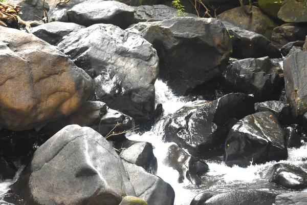 Een waterstroom die tussen de rotsen valt — Stockfoto