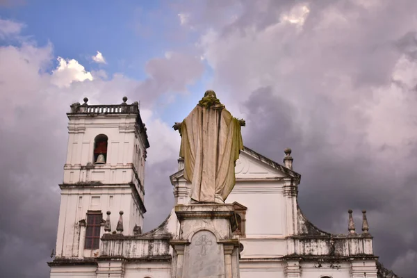 Chapel of St. Catherine with a statue of Lord Jesus from behind with a cloudy sky.