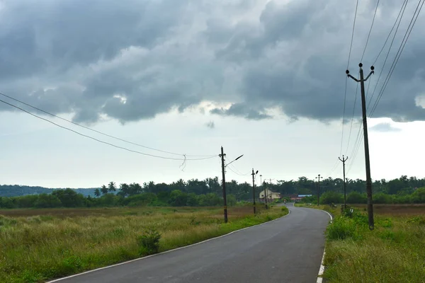 Beautiful Empty road in Autumn season with green fields and cloudy sky in Goa — Stock Photo, Image