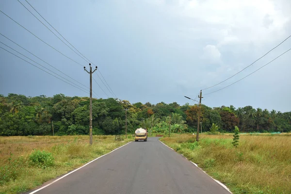 Beautiful road in Autumn season with green fields and cloudy sky in Goa — 스톡 사진