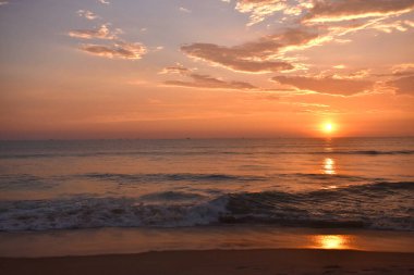 Güzel bulutları ve renkli gökyüzü olan bir denizde gün batımı
