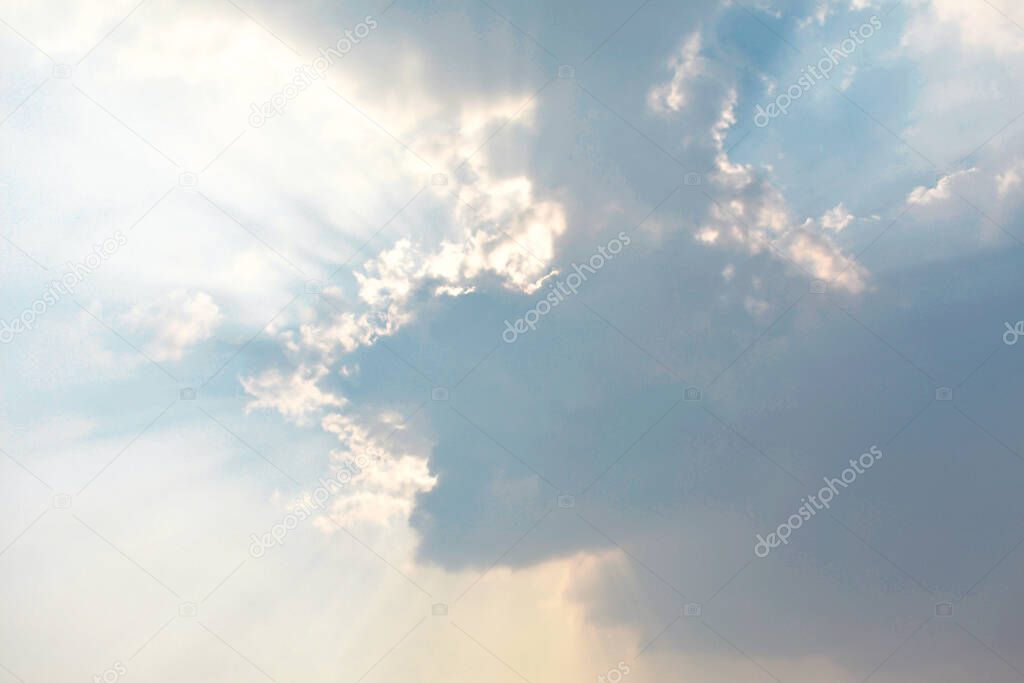 Beautiful rays of sunlight coming out of dark clouds in the sky