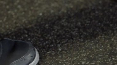 Geceleri betonda ağır çekimde yürüyen bir adam.