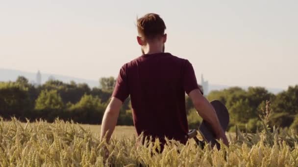 Adulto Caminando Por Hermoso Campo Trigo Sosteniendo Monopatín — Vídeo de stock