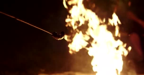 tenant une saucisse sur un feu de camp au ralenti 4k 