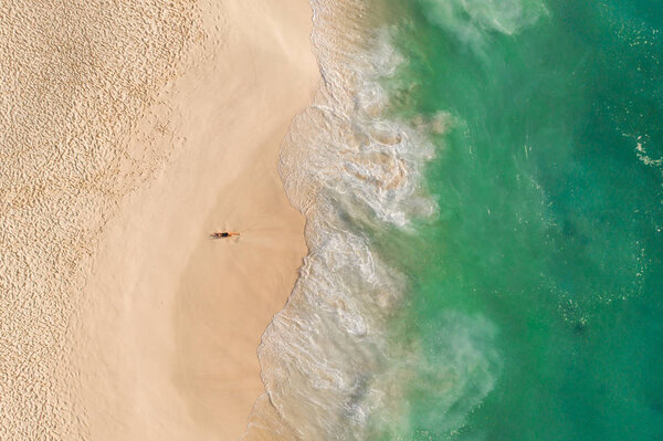 Девочка лежит на берегу океана вид с дрона зеленый океан Нуса Пенида Бали пляж Келингкинг
 