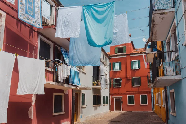Burano adasındaki renkli İtalyan evleri iplerde kurumuş çarşaflar.