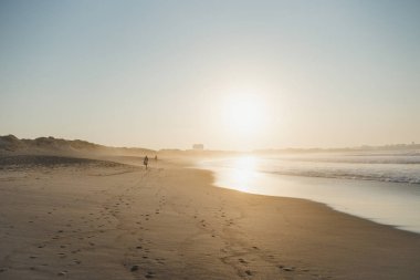 Sunset on the Atlantic ocean sandy beach with people Peniche Portugal