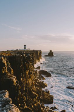Lighthouse on the edge of a cliff big ocean waves crash on a rock Peniche Portugal