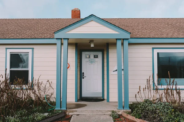 Pescadero, California / United States - December 2018: HI Pigeon Point Lighthouse Hostel front door. Nice blue and white house with green plants in front of the house