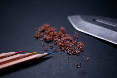 Siyah zemin üzerinde kalem ve bıçak.