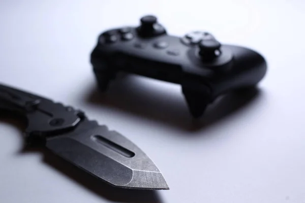 Controlador de videojuegos y cuchillo aislado sobre fondo blanco — Foto de Stock