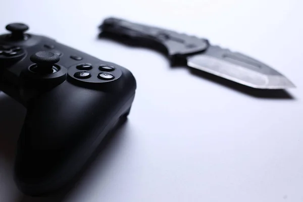 Controlador de videojuegos y cuchillo aislado sobre fondo blanco — Foto de Stock