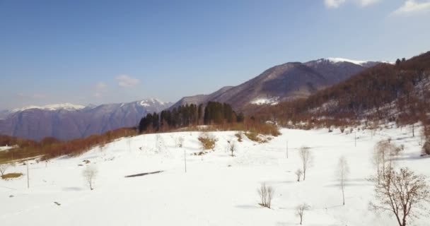Vista aérea de una montaña nevada en un día soleado — Vídeos de Stock