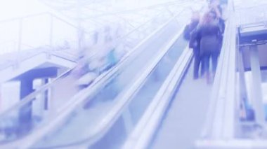 İnsanlar alışveriş merkezinde yürüyen merdiven üzerinde