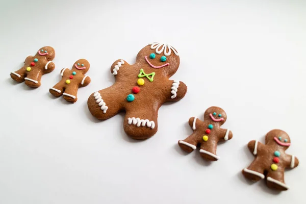 Different sizes of Gingerbread men cookies isolated on white background. Christmas tradition. Top view. — Stock Photo, Image