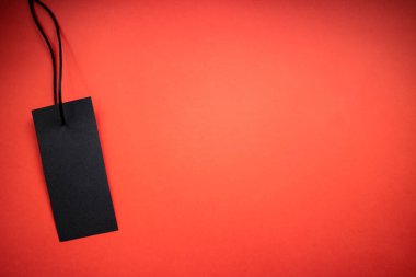 Kırmızı arka planda siyah etiket. Satış konsepti. Boşluğu kopyala.