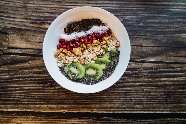 Smoothie tigela isolada com chia, grãos e frutas na mesa de madeira. Vista superior . — Fotografia de Stock