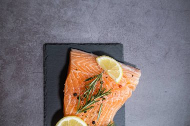 Somon filetosu ve limon ve otlu tahta tabağı. Boşluğu kopyala.