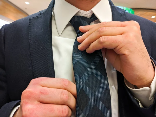 Businessman Fixing His Tie Closeup