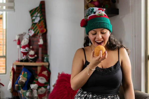 Κολομβιανή γυναίκα τα Χριστούγεννα με καπέλο τρώγοντας τυπικό κολομβιανό φαγητό Royalty Free Φωτογραφίες Αρχείου