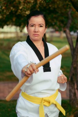 Kolombiyalı, Latin Amerikalı kadın mınçıka ile tekvando yapıyor.