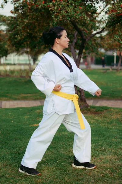 Colombiansk och latinamerikansk kvinna tränar taekwondo försvar i låg vänster knytnäve försvarsposition — Stockfoto