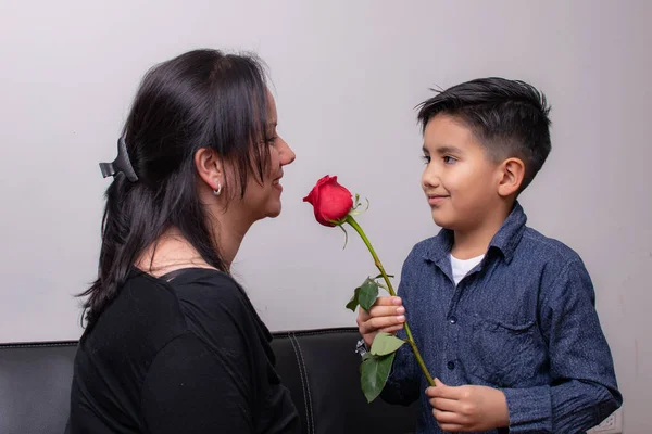 Το αγόρι δίνει ένα τριαντάφυλλο στην Κολομβιανή μητέρα του την ημέρα της μητέρας — Φωτογραφία Αρχείου