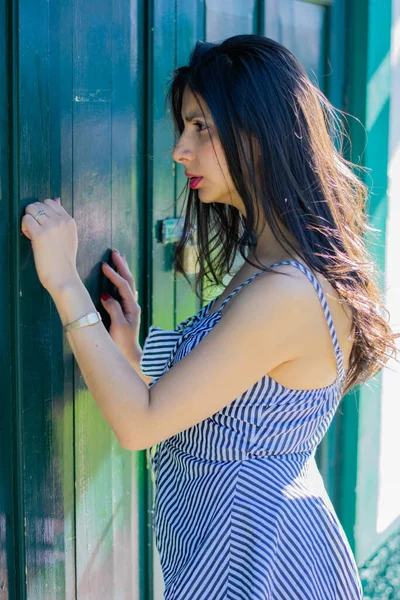 Mujer colombiana caminando por la ciudad tocando una puerta de madera —  Fotos de Stock