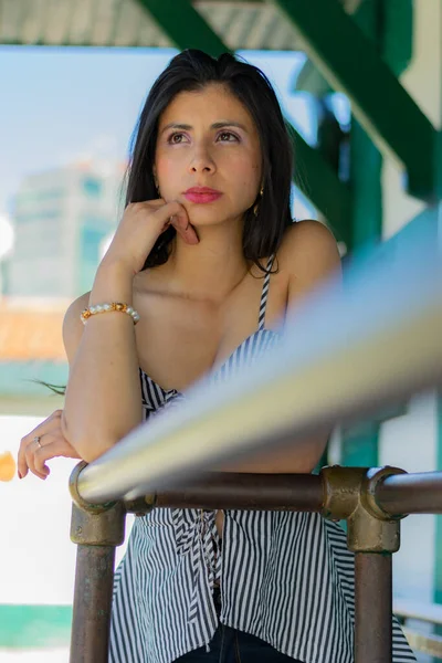 Mujer colombiana muy reflexiva acostada sobre una barandilla —  Fotos de Stock