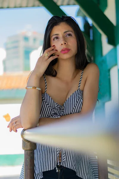 Mujer colombiana muy reflexiva acostada sobre una barandilla —  Fotos de Stock