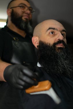 Bogota şehrinde uzun sakallı bir Latin Amerikalı berber çalışıyor.