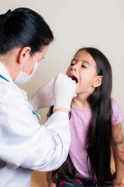 Güzel Kolombiyalı kız danışma odasında pediatristi tarafından muayene ediliyor.