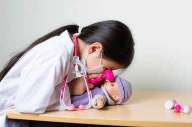 Güzel Kolombiyalı kız oyuncakları inceleyen doktorculuk oynuyor.