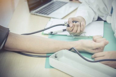 Asyalı doktor kabinedeki erkek hasta için kan basıncını ölçüyor. Tıbbi konsept.. 