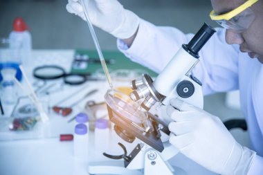 Bilim insanları mikroskop kullanarak laboratuarlardaki covid-19 virüsünü tespit ederek antiretroviral ilaç konseptini korumak için aşılar üzerinde deney yapıyorlar..