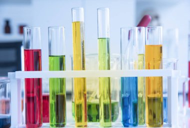 Laboratuvarda birçok kimyasal madde içeren cam test tüpleri. Renk likörüyle farklı renklerde bilimsel bir reaksiyon.