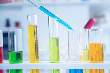 Laboratuvarda birçok kimyasal madde içeren cam test tüpleri. Renk likörüyle farklı renklerde bilimsel bir reaksiyon.