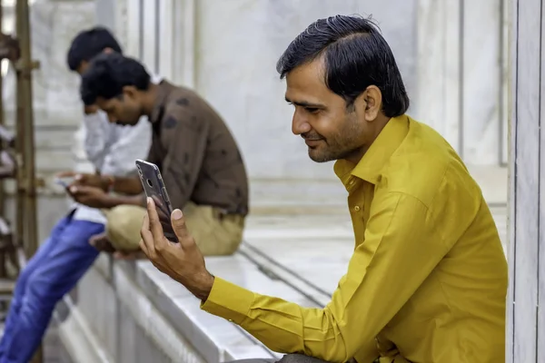 Pune India yakınlarında oturan ve cep telefonunu kullanan Hintli bir adamın samimi portresi..