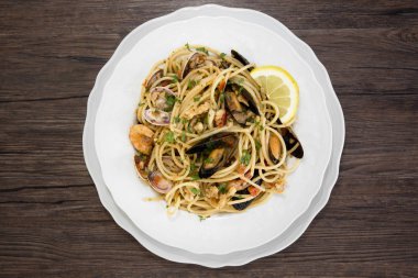 Deniz ürünleri ahşap backgrou üzerinde beyaz seramik tabak spagetti