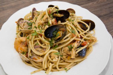 Deniz ürünleri ahşap backgrou üzerinde beyaz seramik tabak spagetti