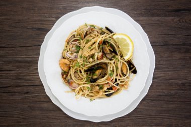 Deniz ürünleri ahşap backgrou üzerinde beyaz seramik tabak spagetti