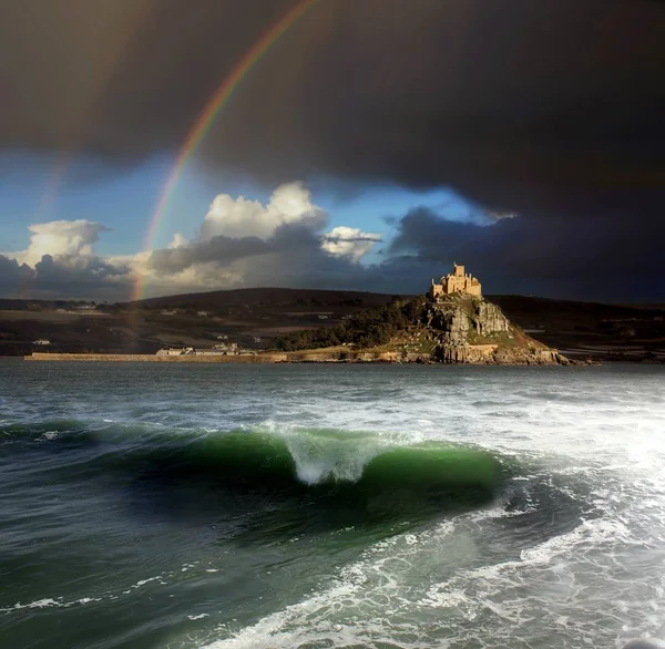 After the storm a beautiful rainbow shines over St Michael\'s Mount Cornwall, wheres theres boats moored safe from the rough sea,