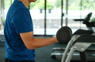 Şehirdeki insanların yaşam tarzları ve spor aktiviteleri konseptindeki spor salonundaki koşu bandında koşan sporcuya yakın çekim