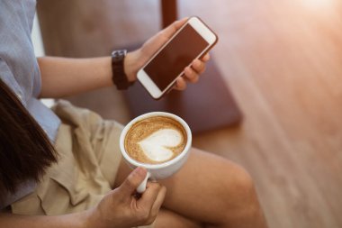 Kadın elleri kahve fincanlarını tutuyor, üstten görünüyor. Fotoğraf yukarıdan çekilmiş, fotokopi alanı ile üstten çekilmiş..