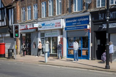 EAST GRINSTEAD, Batı SUSSEX / UK - 20 Nisan 2020: Coronavirus yüzünden Doğu Grinstead 'de postane kuyruğuna girerken sosyal uzaklık. Tanımlanamayan kişiler