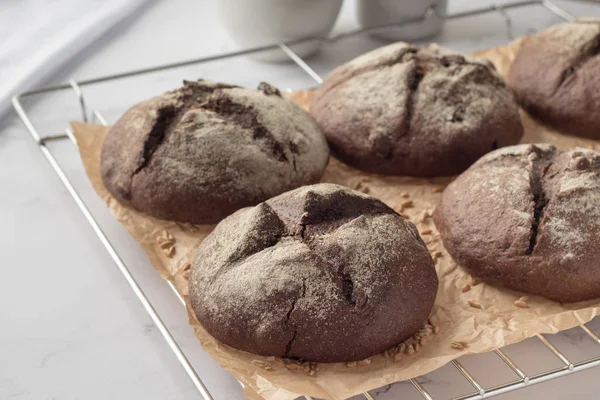 Cooling rack with fresh rye buns on marble table