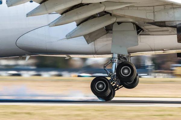 Tren de aterrizaje principal del avión grande durante el aterrizaje cuando el humo de la rueda — Foto de Stock