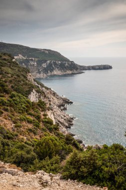 Yunanistan 'ın Kefalonia kentinde açık masmavi sularla kayalık kıyı.